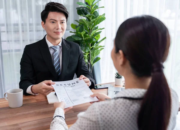 在求职面试期间 亚洲女性应聘者将简历或简历交给了公司总部的人力资源经理 以展示她的求职资格 — 图库照片