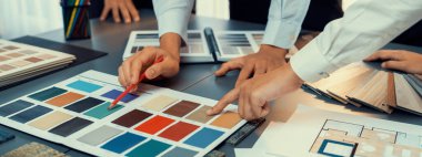 Profesyonel iç mimar ve tasarımcı grubu, ev tasarımı veya yenilenmesi için ofiste renk örnekleri tasarlıyor ve seçiyor. İçgörü