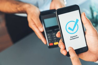 NFC QR kod cihazı ile el ele tutuşan akıllı telefon, hızlı dijital işlemler için temas kurulamayan ödeme kodlarını tarıyor. Modern yaşam tarzı ödeme teknolojisi için cep telefonundaki online bankacılık uygulaması. coşkulu