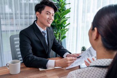 Görüşmeci ve aday arasındaki iş görüşmesi. İK müdürü aday niteliklerini ve özgeçmişli iş başvurusunu soruyor. Başvuru sahibinin işi. Sevinçli.