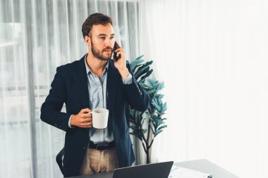 Çalışkan iş adamı, modern ofiste güvenilir bir şekilde müşteriye ikna edici satış çağrıları yapıyor. Ofis çalışanı telefonda konuşuyor ve iş arkadaşlarıyla iş görüşmesi yapıyor. Varlık