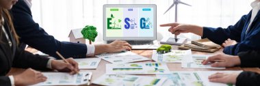 ESG 'nin çevresel sosyal yönetimi, çevre dostu şirket toplantılarında, temiz ve sürdürülebilir gelecekteki ekoloji için çevre korumasını uygulayan iş adamlarıyla dizüstü bilgisayarda sergileniyor. Önde.