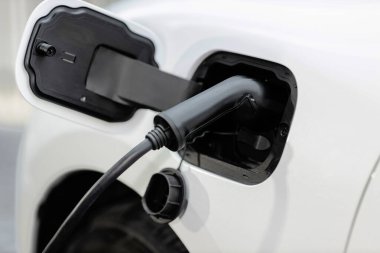 Kapalı elektrikli araç şarj noktasında alternatif temiz enerji şarj edilebilir EV araba tarafından geliştirilmiş çevresel otomotiv endüstrisi konsepti için şarj istasyonundan kabloya bağlandı