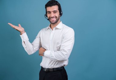 Kulaklık takan ve resmi kıyafet giyen erkek çağrı merkezi operatörü, izole edilmiş arkaplan portresindeki kişiselleştirilebilir boşlukta el hareketini gösteriyor. Müşteri hizmetleri ve destek için profesyonel gülümseme. coşkulu