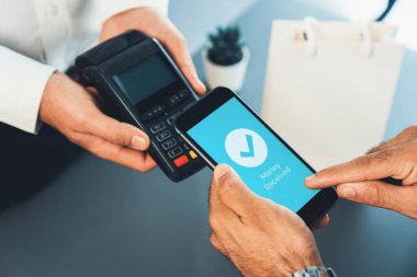NFC QR kod cihazı ile el ele tutuşan akıllı telefon, hızlı dijital işlemler için temas kurulamayan ödeme kodlarını tarıyor. Modern yaşam tarzı ödeme teknolojisi için cep telefonundaki online bankacılık uygulaması. coşkulu