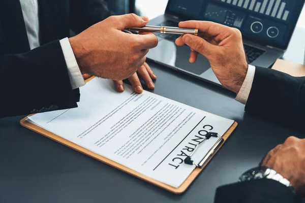 stock image Two businesspeople sit across the desk as business deal is taking place. Corporate attorney giving a pen for client or partner to sign contract paper, sealing the deal with signature. Fervent