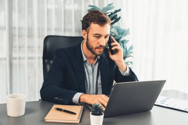 Çalışkan ve çalışkan iş adamı, cep telefonuyla müşterileriyle konuşurken, modern çoklu görev yapan ofis çalışanı yaşam tarzını sergiliyor. Varlık