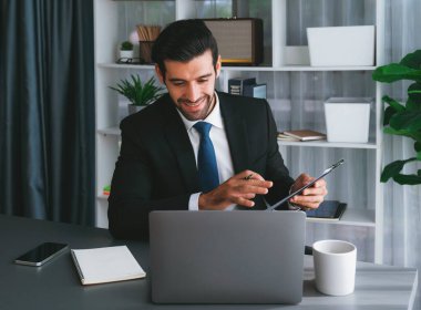 Siyah takım elbiseli profesyonel işadamı, online toplantı sırasında dizüstü bilgisayarla finansal veri ya da BI belgesi sunuyor. Etkili uzaktan çalışmanın sanal toplantı sunumuyla uzaktan çalışma konsepti. Coşkulu