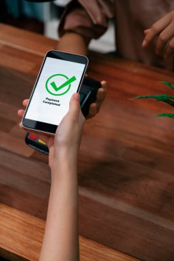 QR kodu parasız ödeme taraması için ekranda gösterilir. Kapalı eller, mobil uygulamadan elektronik işlem yoluyla para aktarmak için akıllı telefonu tutuyor. Hızlı ödeme için barkod teknolojisi. Coşkulu.