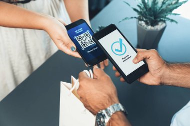 Parasız ödeme taraması için QR kodu ekranda görüntülendi. Kapalı eller, mobil uygulamadan elektronik işlem yoluyla para aktarmak için akıllı telefonu tutuyor. Hızlı ödeme için barkod teknolojisi. Coşkulu