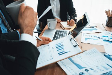 Ofis masasındaki finansal veri raporlarını analiz eden çeşitli bir grup iş analisti. Stratejik pazarlama planlaması için iş istihbarat analizine göre grafikler ve grafikler.