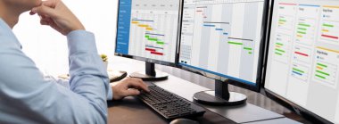 Proje yöneticisi, ekranda gantt grafik yazılım gösterimi kullanılarak ofis için iş programları planlıyor. Modern iş yönetimi ve iş akışı organizasyonu. Önde.