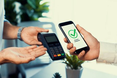 NFC QR kod cihazı ile el ele tutuşan akıllı telefon, hızlı dijital işlemler için temas kurulamayan ödeme kodlarını tarıyor. Modern yaşam tarzı ödeme teknolojisi için cep telefonundaki online bankacılık uygulaması. coşkulu