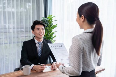 Görüşmeci ve aday arasındaki iş görüşmesi. İK müdürü aday niteliklerini ve özgeçmişli iş başvurusunu soruyor. Başvuru sahibinin işi. Sevinçli.