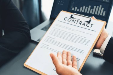 Kapanış toplantısı, iş adamı sözleşmenin şartlarını ve şartlarını dikkatle gözden geçiriyor. Şirket avukatı sözleşme anlaşmasında danışmanlık yapar. Coşkulu