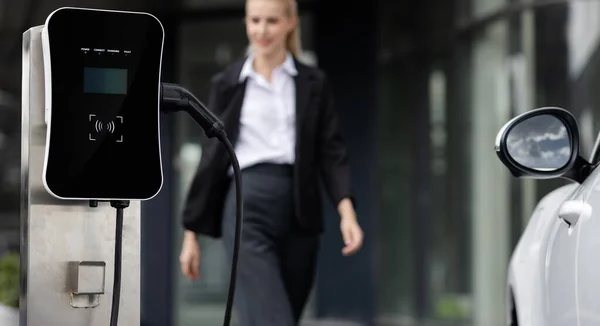 Focus Public Charging Station Electric Car Blurred Progressive Businesswoman Walking — Zdjęcie stockowe