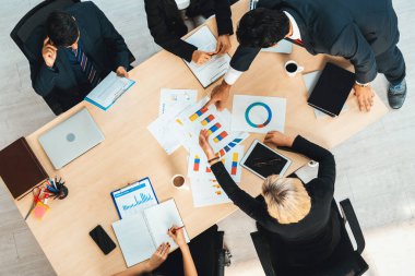 İş adamları grup toplantısı ofiste yukarıdan çekildi. İş kadınları, iş adamları ve ofis çalışanları toplantı masasında proje planlama belgeleriyle takım konferansında çalışıyorlar. Jivy
