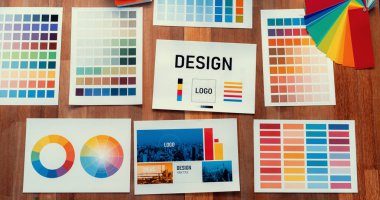 Grafik tasarım konsepti için çalışma masasının üzerine düzgünce düzenlenmiş çeşitli renk paleti fikir kağıtlarının panorama çekimi. Benzersiz dijital sanat tasarımı için renk örnekleri ve seçim. İnceleyin