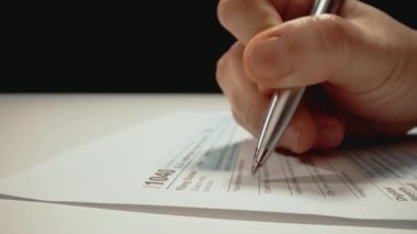 Şirket muhasebecisinin ya da bireysel vergi mükelleflerinin vergi formlarını doldurup vergi sezonuna hazırlanan ve mali rapor sunan 1040 vergi formunu doldurdukları yakın çekim makro çekimi..