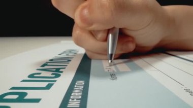 İş başvuru formu belgesine kişisel bilgileri dolduran ve isim yazan başvuru sahiplerinin yakın çekim makro çekim hareketi. İşsiz aday için istihdam ve iş olanağı.
