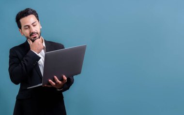 Yenilikçi teknoloji kavramına sahip başarılı bir iş adamı, ayakta duran, dizüstü bilgisayarı tutan ve telif alanı arka planında reklam ya da tanıtım için heyecanla gülümseyen. Coşkulu