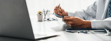 Doktor, tibbi raporu laptopla dikkatlice gözden geçir ve hastaların doktor muayenehanesinde etkili bir sağlık tedavi planı için hastalık teşhisi koy. Profesyonel tıbbi değerlendirme. Neoterik