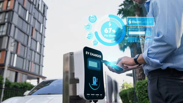 Üzletember Ellenőrzi Akkumulátor Állapotát Hologram Okostelefon Alkalmazás Míg Autó Újratöltés — Stock Fotó