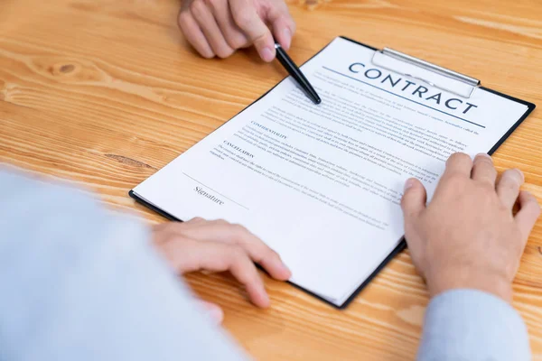 ビジネスマンは企業パートナーシップの契約書を注意深くレビューします 専門的なビジネスの決定のための会議のテーブルの顧客の読書契約の契約および条件 エンティティ — ストック写真