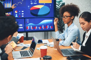 Çok ırklı analist ekibi toplantı masasındaki mali raporu analiz etmek için BI gösterge tablosunu kullanıyor. Çeşitli iş adamlarından oluşan bir grup, iş pazarlama kararı için FIntech 'in veri analizini kullanır. Uyum