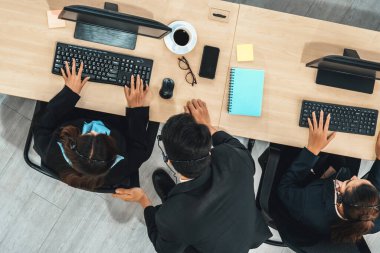 Ofiste bilgisayar başında çalışan, kulaklık takan iş adamları. Jivy