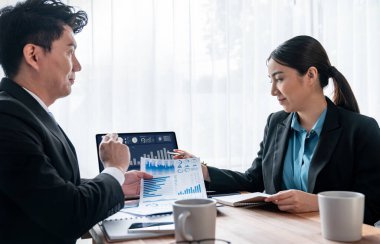 Ofisteki analist ekibi veri analizi ve pazarlama stratejisini güçlü takım çalışmasıyla yapılan toplantıda iş performansını artırmak için BI gösterge paneli ve istatistikleri kullanarak tartışıyor. Sevinçli.