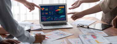 Panorama analist ekibi, FBI Fintech 'i kullanarak dizüstü bilgisayarla mali raporu analiz ediyor. İş adamları iş görüşü için dizüstü bilgisayarda gösterilen kontrol panelini inceliyor. İnceleyin