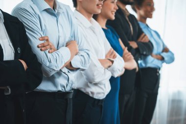 Profesyonel iş adamlarından oluşan çeşitli gruplar modern kurumsal ofiste çapraz kol hareketi ile sırada bekliyor. Mutlu ve gülümseyen, çok ırklı ofis çalışanı ekip birleşmesi ve birlikte başarılı. Uyum