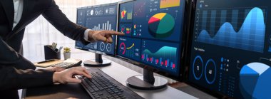 Analizci veri analizi ya da bilgisayar monitöründeki BI gösterge paneli üzerinde çalışıyor. Ticari pazarlama ve strateji planlaması için Fintech 'in şirket ofisindeki finansal verilerini analiz eden iş ekibi. Önde.