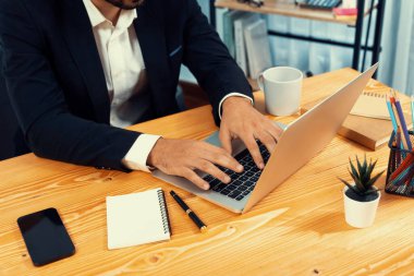 Modern ofis masasındaki modern profesyonel iş adamı çalışmak ve notlar yazmak için dizüstü bilgisayar kullanıyor. Ofisinde bilgisayar defteri üzerinde çalışan çalışkan bir ofis çalışanı. coşkulu