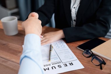 Mutlu iş adamları başarılı bir toplantıdan ya da özgeçmişle iş görüşmesinden sonra el sıkışırlar. İnsan Kaynakları müdürü, yeni çalışanı tebrik etmek için iş başvurusunda bulunan kişiye elini uzattı. Sevinçli.