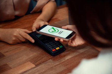 QR kodu parasız ödeme taraması için ekranda gösterilir. Kapalı eller, mobil uygulamadan elektronik işlem yoluyla para aktarmak için akıllı telefonu tutuyor. Hızlı ödeme için barkod teknolojisi. Coşkulu.