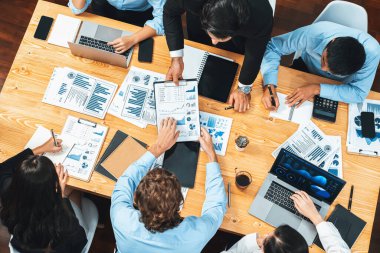 Üst düzey iş analist grubu toplantı masasındaki finansal veri raporunu analiz ediyor. İş zekası analizine göre çizelge ve grafik paneli. Çok titiz.