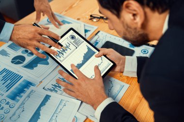 Analist ekibi, tablet ekranında veri bilimi yazılım görüntüsü kullanarak dijital paneldeki finansal verileri analiz ediyor, grafiği ve grafiği analiz ediyor. İş zekası ve Fintech. Coşkulu
