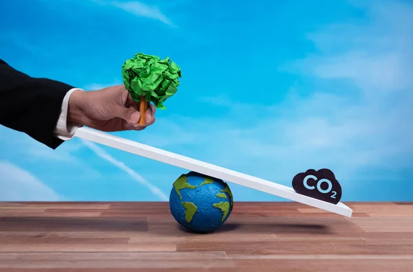 商人在二氧化碳符号的作用下 拥有了一株大规模的纸树 通过企业生态责任促进了森林再生 以此作为减少绿色环境二氧化碳排放的可持续解决方案 改变了 — 图库照片