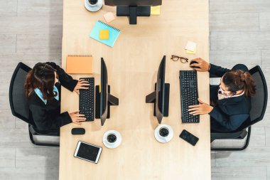 Ofiste bilgisayar başında çalışan, kulaklık takan iş adamları. Jivy