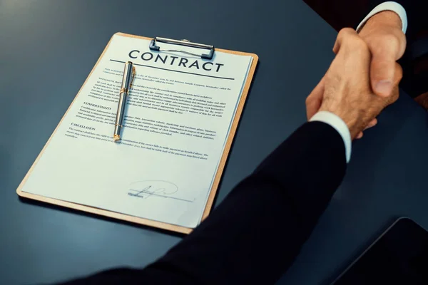 重点业务合同文件与模糊的背景握手后 成功地完成了业务交易 签订了伙伴关系协议 法律文件和握手作为正式协议 — 图库照片