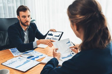 Ofisteki analist ekibi, iş performansını artırmak için tablet ekranında grafik ve grafik olan BI panelini kullanarak çalışma alanındaki pazarlama stratejisi için finansal veri analizi yapmakla meşgul. Varlık