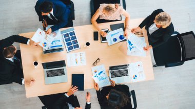 İş adamları grup toplantısı ofiste yukarıdan çekildi. İş kadınları, iş adamları ve ofis çalışanları toplantı masasında proje planlama belgeleriyle takım konferansında çalışıyorlar. Jivy