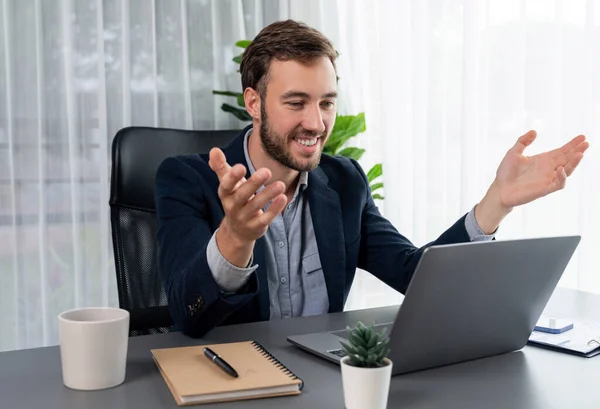 stock image Businessman holds virtual office meeting from office desk, discussing with online video conference using webinar application on laptop for distant communication with remote workers. Entity