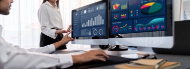 Analizci veri analizi ya da bilgisayar monitöründeki BI gösterge paneli üzerinde çalışıyor. Ticari pazarlama ve strateji planlaması için Fintech 'in şirket ofisindeki finansal verilerini analiz eden iş ekibi. Önde.