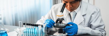 Bilim adamları yeni bir aşı ilacı ya da antibiyotik geliştirmek için mikroskop kullanarak tıbbi laboratuarda kimyasal deney yapıyorlar. Biyoteknoloji laboratuvarı ve tıp araştırma konsepti. Neoterik
