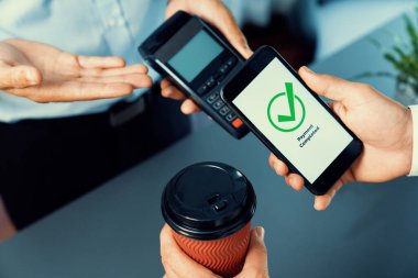 NFC QR kod cihazı ile el ele tutuşan akıllı telefon, hızlı dijital işlemler için temas kurulamayan ödeme kodlarını tarıyor. Modern yaşam tarzı ödeme teknolojisi için cep telefonundaki online bankacılık uygulaması. coşkulu