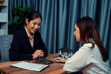 Temsilciyle ev kredisi sözleşmesini gözden geçiriyorum. Mali belgeleri ve vergi oranlarını, mülkiyet sahibi olmak için hesap makinesiyle analiz ediyorum. Yeni ev alımı ve finansman için anahtar imza. Coşkulu.