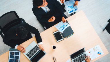 İş adamları grup toplantısı ofiste yukarıdan çekildi. İş kadınları, iş adamları ve ofis çalışanları toplantı masasında proje planlama belgeleriyle takım konferansında çalışıyorlar. Jivy